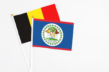 Belize and Belgium stick flags on white background. High quality fabric, miniature national flag. Peaceful global concept.White floor for copy space.