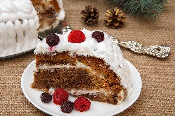 Sliced biscuit cake decorated with whipped cream and raspberries