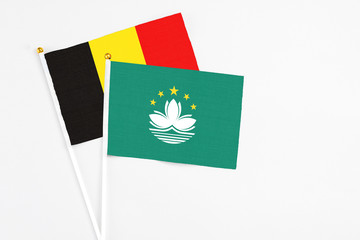 Macao and Belgium stick flags on white background. High quality fabric, miniature national flag. Peaceful global concept.White floor for copy space.