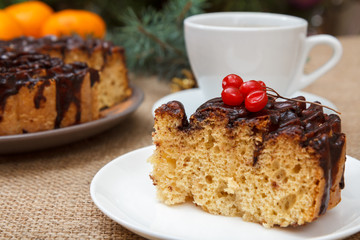 Chocolate cake decorated with bunch of viburnum and cup of coffee.