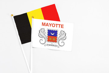 Mayotte and Belgium stick flags on white background. High quality fabric, miniature national flag. Peaceful global concept.White floor for copy space.