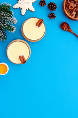 Make festive drink eggnog - ingredients on blue background top view frame copy space