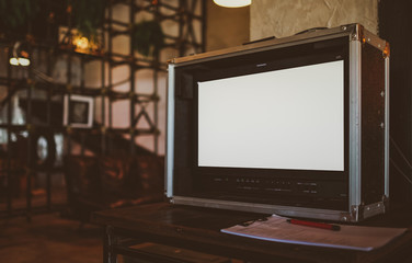 Blank space of monitor screen on vintage background with warm light, use to put movie on blank screen
