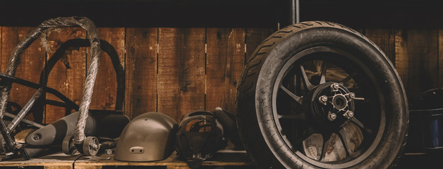Motorcycle wheel on the floor with workshop tools, vintage garage, with blank copy space