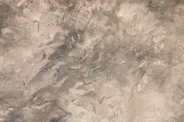 The rough beautiful abandoned concrete gray wall with spots and bumps is shot on a clear sunny day. Abstract modern trendy grunge texture background. Design element, copy space.