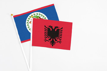 Albania and Belize stick flags on white background. High quality fabric, miniature national flag. Peaceful global concept.White floor for copy space.