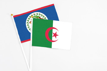 Algeria and Belize stick flags on white background. High quality fabric, miniature national flag. Peaceful global concept.White floor for copy space.