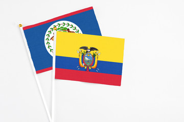 Ecuador and Belize stick flags on white background. High quality fabric, miniature national flag. Peaceful global concept.White floor for copy space.