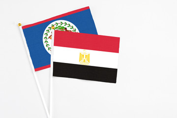 Egypt and Belize stick flags on white background. High quality fabric, miniature national flag. Peaceful global concept.White floor for copy space.