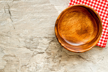 Preparing for lunch - empty wooden bowl closeup on grey background top view copy space
