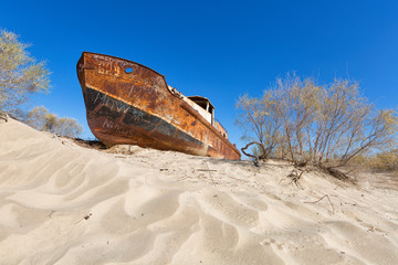 Rustic boat on a ship graveyard on a desert around Moynaq, Aral sea, Uzbekistan