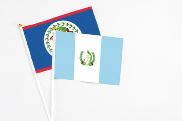 Guatemala and Belize stick flags on white background. High quality fabric, miniature national flag. Peaceful global concept.White floor for copy space.