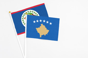 Kosovo and Belize stick flags on white background. High quality fabric, miniature national flag. Peaceful global concept.White floor for copy space.