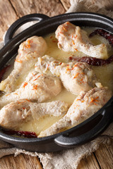 Indian chicken Rezala with spicy yogurt sauce close-up in a pan. vertical