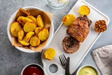 Meat with baked potatoes and sauces. top view.