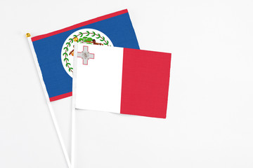 Malta and Belize stick flags on white background. High quality fabric, miniature national flag. Peaceful global concept.White floor for copy space.