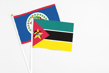 Mozambique and Belize stick flags on white background. High quality fabric, miniature national flag. Peaceful global concept.White floor for copy space.