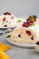 Meringue roll cake with cream and raspberries. Roulade, summer dessert, closeup.
