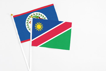 Namibia and Belize stick flags on white background. High quality fabric, miniature national flag. Peaceful global concept.White floor for copy space.