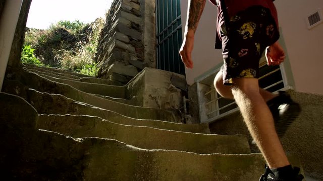 Young Backpacker Walks Up Stairs In Italian Town