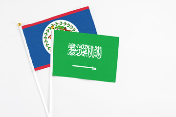 Saudi Arabia and Belize stick flags on white background. High quality fabric, miniature national flag. Peaceful global concept.White floor for copy space.