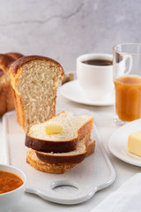 Freshly brioche bread and butter, juice and jam. Continental breakfast.