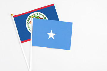 Somalia and Belize stick flags on white background. High quality fabric, miniature national flag. Peaceful global concept.White floor for copy space.