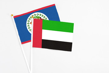 United Arab Emirates and Belize stick flags on white background. High quality fabric, miniature national flag. Peaceful global concept.White floor for copy space.