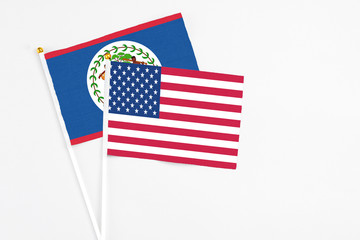 Fototapeta premium United States and Belize stick flags on white background. High quality fabric, miniature national flag. Peaceful global concept.White floor for copy space.