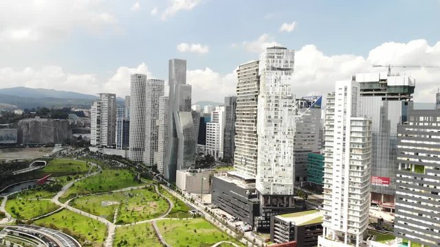 Aerial view of the skyline in Santa Fe and the public park La Mexicana on a sunny day. Drone flying sideways with a blue sky as background