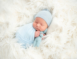 Sleeping newborn hugging toy