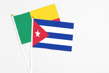 Cuba and Benin stick flags on white background. High quality fabric, miniature national flag. Peaceful global concept.White floor for copy space.