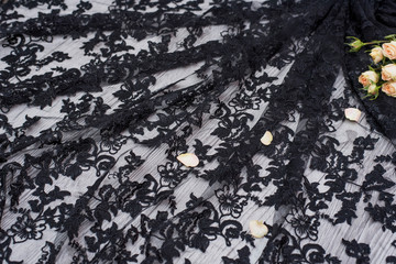 White wooden background with white spring flowers roses and lace ribbon. Happy womans day. The texture of lace on wooden background. Black