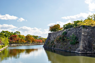 Fototapeta na wymiar Defensive stone wall of Osaka-jo castle in autumn