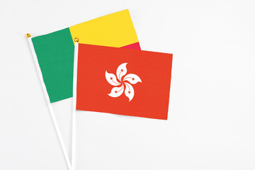Hong Kong and Benin stick flags on white background. High quality fabric, miniature national flag. Peaceful global concept.White floor for copy space.