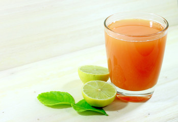 Mixed fruits juice and slice of lemon, leaf on wood table background