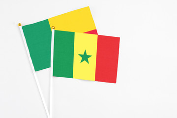 Fototapeta premium Senegal and Benin stick flags on white background. High quality fabric, miniature national flag. Peaceful global concept.White floor for copy space.