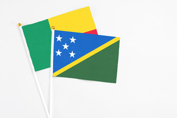 Solomon Islands and Benin stick flags on white background. High quality fabric, miniature national...