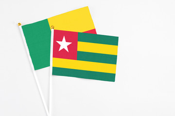 Togo and Benin stick flags on white background. High quality fabric, miniature national flag. Peaceful global concept.White floor for copy space.