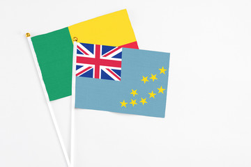 Fototapeta premium Tuvalu and Benin stick flags on white background. High quality fabric, miniature national flag. Peaceful global concept.White floor for copy space.