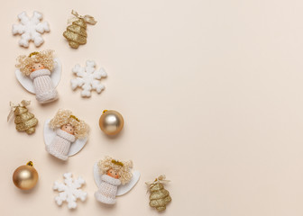 Christmas border made of christmas balls, angels and snowflakes on beige background. Top view, flat lay