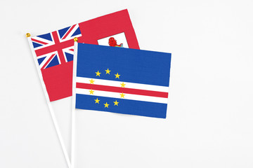 Cape Verde and Bermuda stick flags on white background. High quality fabric, miniature national flag. Peaceful global concept.White floor for copy space.