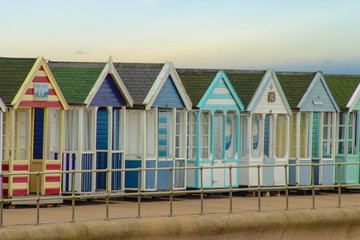 Fototapeta na wymiar Colorful beach huts, sea coast cabins for summer holiday vacation, Southwold UK