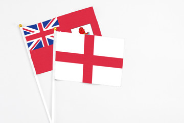 England and Bermuda stick flags on white background. High quality fabric, miniature national flag. Peaceful global concept.White floor for copy space.