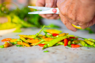 The hand that is cutting the chili seeds