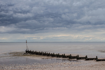 Low tide on coast sea long muddy beachwith broken pier. drought