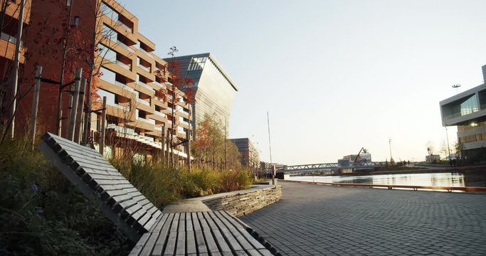 4K low angle wide shot with forward slide motion of Lambda, the new Edvard Munch museum, with famous paintings like The Madonna, in a late autumn sunset in the new Bj&oslash;rvika quarter in Oslo, Norway.