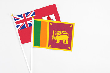 Sri Lanka and Bermuda stick flags on white background. High quality fabric, miniature national flag. Peaceful global concept.White floor for copy space.