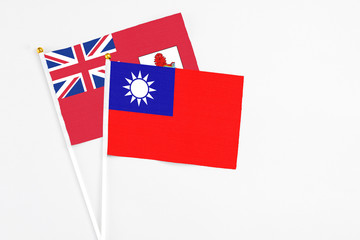 Taiwan and Bermuda stick flags on white background. High quality fabric, miniature national flag. Peaceful global concept.White floor for copy space.