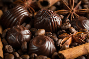 Assortment of white, dark, and milk chocolate. Chocolate with cream, nuts, almonds, hazelnuts and cinnamon with coffee beans. Sweet food and no diet concept.